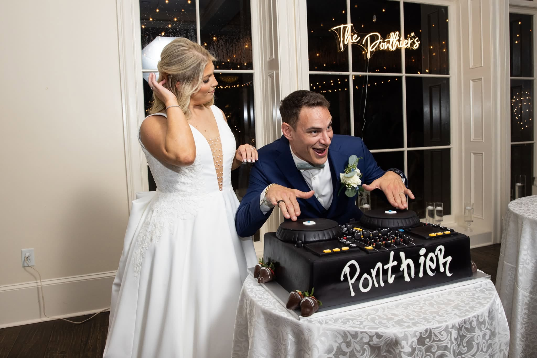 Neil and Raylynn Ponthier with their wedding cake shaped like a DJ controller