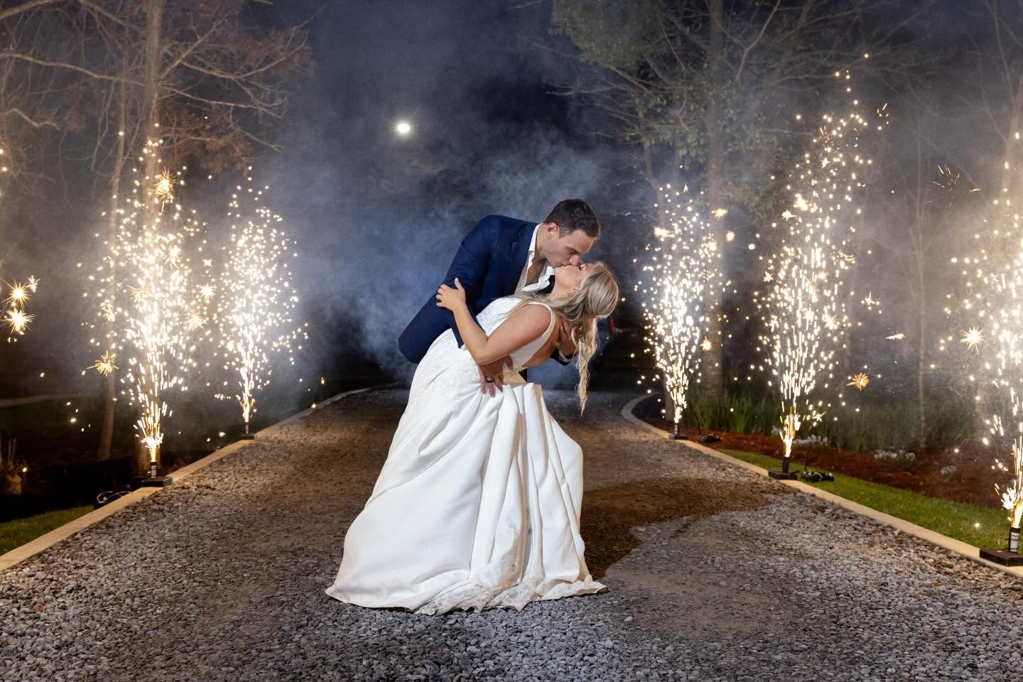 Bride and groom kissing during their sparkler send-off
